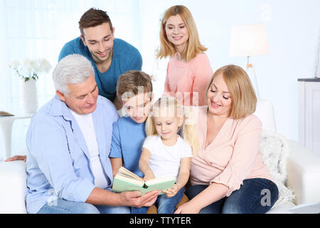 Glückliche Familie Lesung buchen Sie im Wohnzimmer Stockfoto