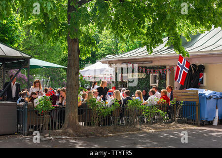 Oslo, Blick im späten Frühling auf Norweger, die sich an Tischen in einem Restaurant im Olaf Ryes Plass Park im Grunerlokka-Viertel von Oslo, Norwegen, entspannen. Stockfoto