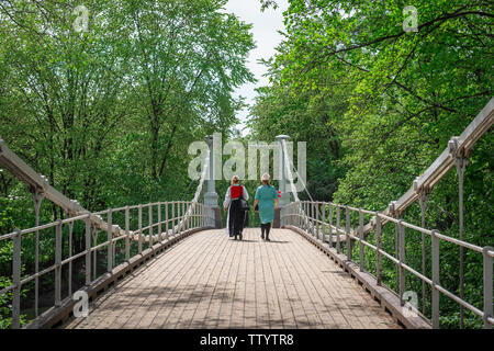 Frauenbrücke, Rückansicht von zwei norwegischen Frauen, die die Aamodt-Brubrücke über dem Fluss Akerselva im Bezirk Grunerlokka in Oslo, Norwegen, überqueren. Stockfoto