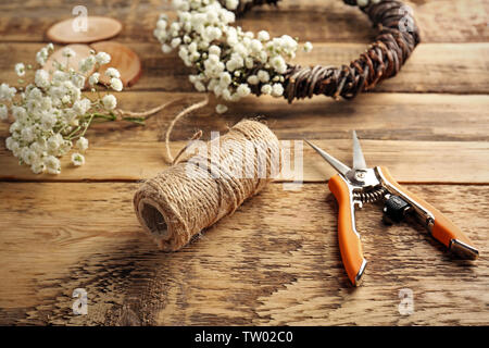 Schöne Blumen Kranz mit Tools zur Hand - auf hölzernen Hintergrund Stockfoto