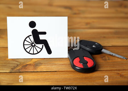 Autoschlüssel und Karte mit Handicap Zeichen auf Holz- Hintergrund Stockfoto