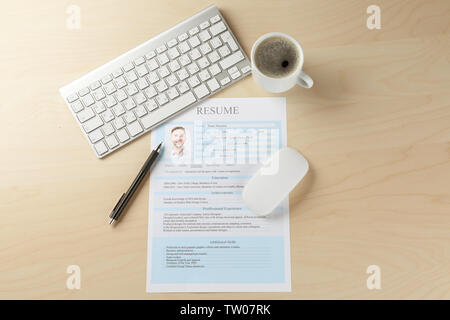 Abgeschlossen CV, eine Tastatur und eine Tasse Kaffee auf hölzernen Tisch Stockfoto