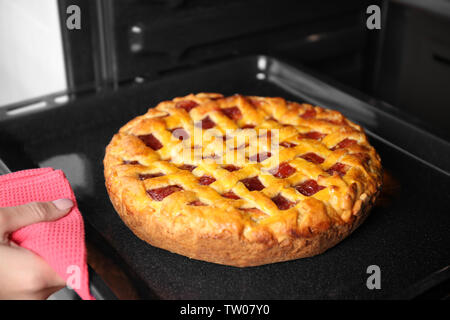 Frau Hand, Backblech, mit leckeren Kuchen aus dem Ofen Stockfoto