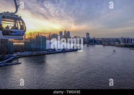 Royal Docks, London, UK, 16. Februar 2018: Blick auf die Seilbahn Kapsel über die Themse reisen mit der O2-Dome und Canary Wharf bei Sonnenuntergang. Stockfoto