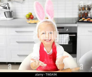 Süße kleine Mädchen mit Händen in Mehl in der Küche Stockfoto