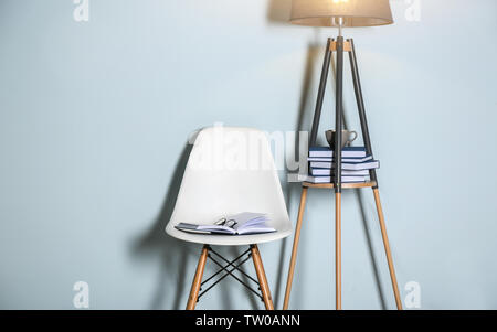Aufgeschlagenes Buch mit Brille auf weißem Stuhl im Zimmer Stockfoto
