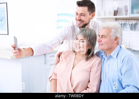 Junger Mann mit mittleren gealterten Eltern unter selfie Stockfoto