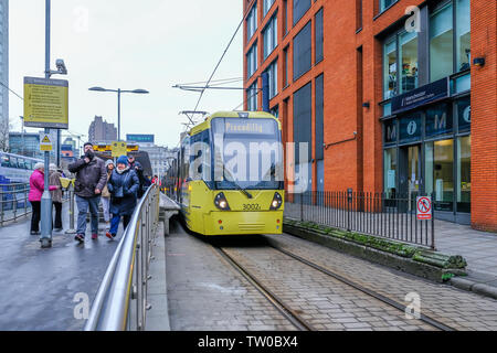 Die Piccadilly, Manchester, UK - Januar 19, 2019: Gelb Straßenbahn an der Haltestelle Picadilly mit Passagieren die Station zu verlassen 1. Stockfoto