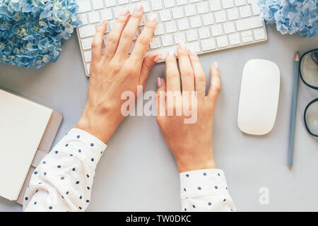 Office Konzept, Blick von oben auf die Hände in einer Polka-dot Shirt die Eingabe über die Tastatur des Computers, modische business lady Blogger hält Ihr blog auf der Website. Stockfoto