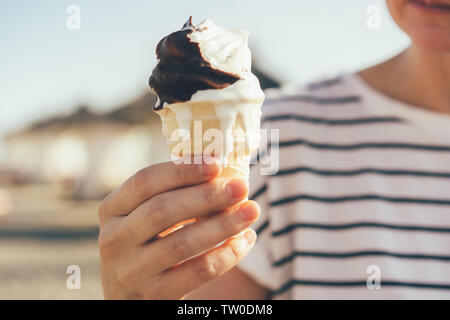 Nahaufnahme einer Hand, die schmelzenden Eis in Kegel. Stockfoto