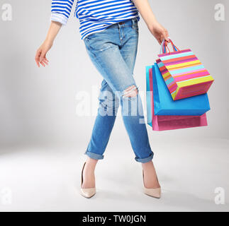 Woman's Beine und Einkaufstaschen auf hellen Hintergrund Stockfoto