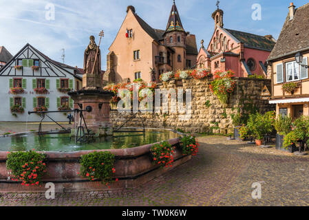 Malerischer Ort im alten Dorf Eguisheim, Elsass, Frankreich, malerischen Platz mit Schloss Château de Saint-Léon-Pfalz und gut Stockfoto