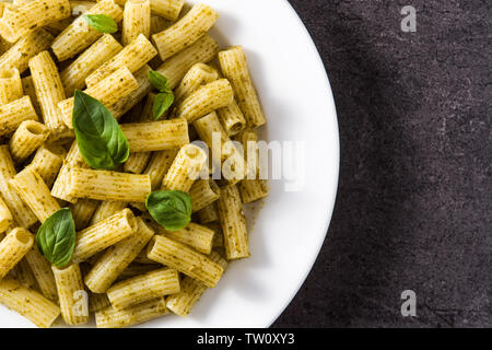 Nudeln mit Pesto auf schwarzem Hintergrund. Ansicht von oben. Copyspace Stockfoto
