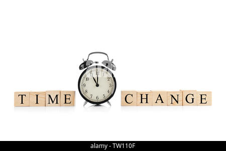 Holzwürfel mit Platz für Text und Wecker auf weißem Hintergrund Stockfoto