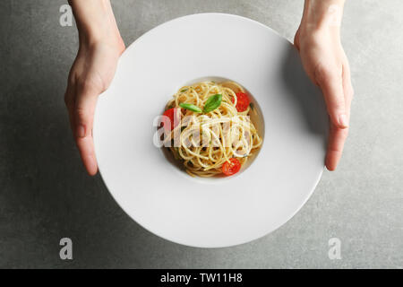 Frau hält Teller mit leckeren Pasta Stockfoto