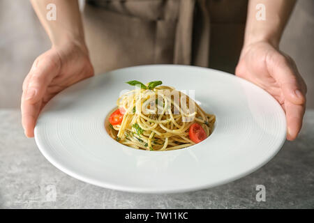 Frau hält Teller mit leckeren Pasta Stockfoto