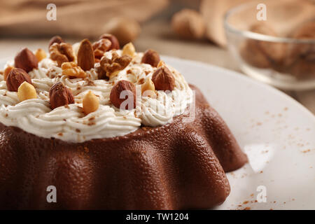 Schokolade Wackelpudding mit Nüssen und Sahne auf Platte, Nahaufnahme Stockfoto