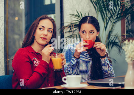 Bild eines zwei glückliche Mädchen Freunden im Cafe sitzen Sprachen miteinander Kaffee trinken, an jemanden gerichtet ist. Stockfoto