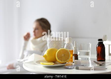 Medikamente und Zitronen mit unscharfen kranke Frau auf Hintergrund Stockfoto