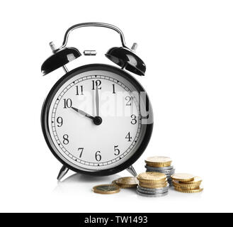 Wecker und Münzen auf weißem Hintergrund Stockfoto