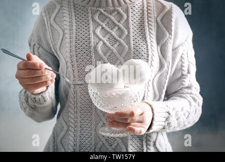 Weibliche Hände halten crystal Bowl mit Schneebällen auf unscharfen Hintergrund Stockfoto