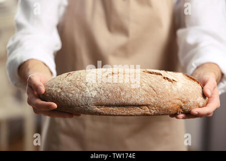 Männliche Hände halten frisch gebackenem Roggenbrot, Nahaufnahme Stockfoto