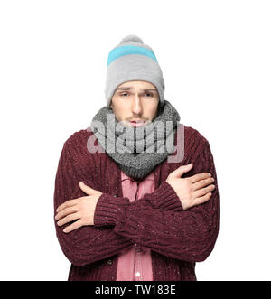 Junger Mann in warme Kleidung zitternd vor Kälte auf hellen Hintergrund Stockfoto