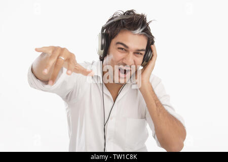 Indischer junge Mann Musikhören mit Kopfhörer Stockfoto
