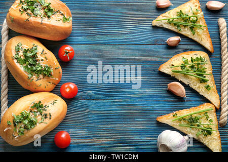 Leckeres Brot mit geriebenem Käse, Knoblauch und Kräutern auf Schneidebrett Stockfoto