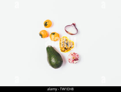 Minimale flach Anordnung von gesunden Verhältnis von reife Avocados, Nüsse, Zwiebeln, Knoblauch und gelbe Kirschtomaten auf weißem Hintergrund. Stockfoto