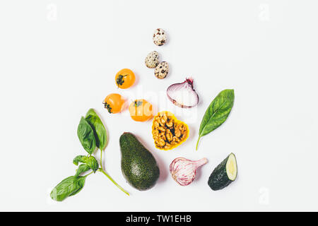 Flach gesunde Ernährung Zusammensetzung der reife Avocados, Nüsse, Tomaten, Knoblauch, Zwiebeln und grünen auf weißem Hintergrund. Stockfoto