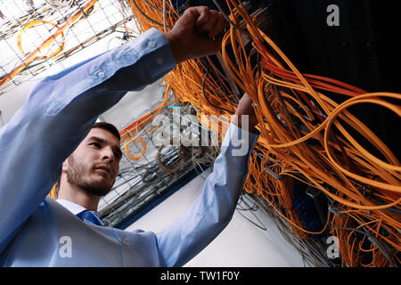 Hübscher junger Ingenieur Anschlussleitungen im Server Raum Stockfoto
