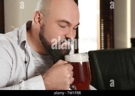 Bärtiger Mann trinkt Bier im Pub Stockfoto