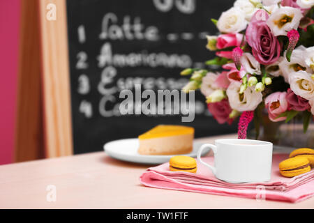Tasse Kaffee, leckeren Kuchen und Schönen Blumenstrauß im Cafe Stockfoto