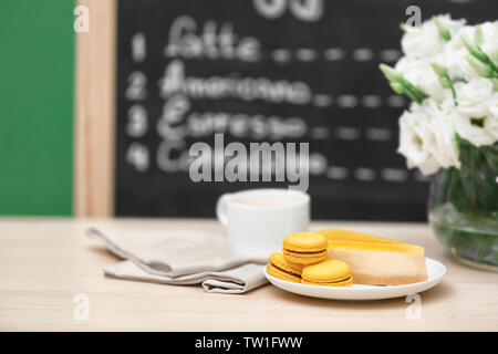 Tasse Kaffee, leckeren Kuchen und Schönen Blumenstrauß auf dem Tisch im Cafe Stockfoto