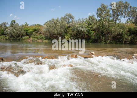 Hetzende Daly River Gewässer über Riverbed Felsen mit buschland Grün im Northern Territory von Australien Stockfoto