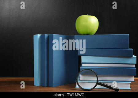 Bücher und Apple auf blackboard Hintergrund Stockfoto