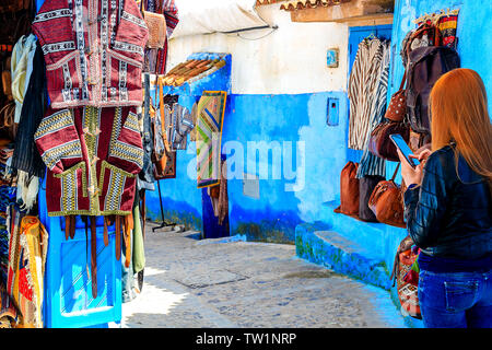 CHEFCHAOUEN, MAROKKO - April 24, 2019: Bunte marokkanische Stoffen und handgefertigte Souvenirs auf der Straße in die blaue Stadt Chefchaouen, Marokko, Afrika. Stockfoto