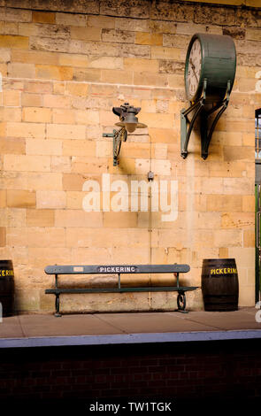 Die Station clock Zwerge eine Sitzbank bei Pickering Station auf der North Yorkshire Moors Railway. Stockfoto