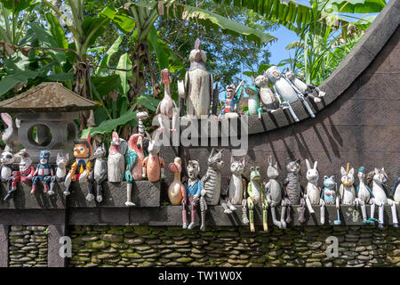 Alte hölzerne Souvenirs Spielzeug auf dem Stein Zaun in der Nähe der Puppe shop in Ubud, Bali, Indonesien. Nahaufnahme Stockfoto