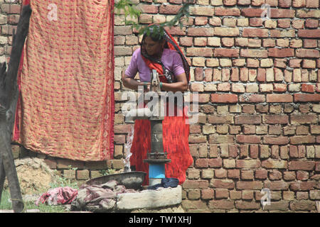 Frau Zeichnung Wasser aus einer Wasserpumpe, Indien Stockfoto