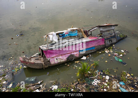 Eine versunkene traditionelle vietnamesische River Boat (Haus Boot) in einem Kanal in den Fluss Saigon in Ho Chi Minh City, Vietnam. Verlust und Tragödie Stockfoto