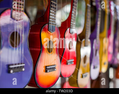 Mehrfarbige Gitarren. Wenig Gitarren in verschiedenen Farben. Das Bild wurde auf dem Öffnen von Aperture. Eine Gitarre in der Rest ist verschwommen. Stockfoto