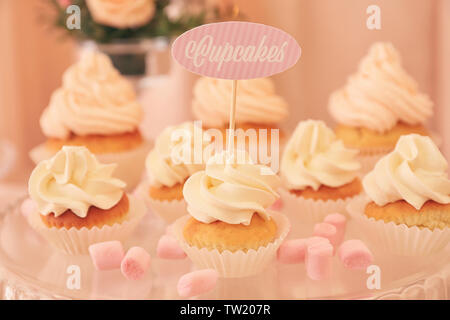 Standfuß aus Glas mit leckeren Cupcakes, Nahaufnahme Stockfoto