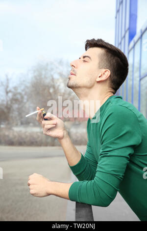 Junger Mann rauchen Zigarette im Freien Stockfoto