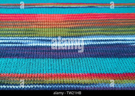 Nahaufnahme der Textur von Türkis Blau, mit farbenfrohen, gestreiften Alpaka gestrickte Wolle Stoff für Hintergrund oder Banner Stockfoto