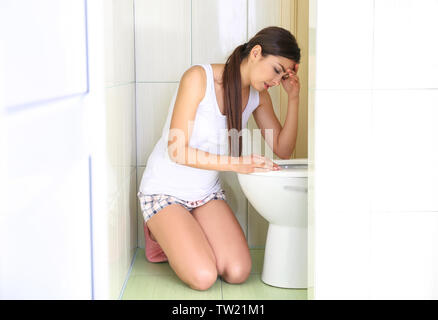 Junge erbrechen Frau in der Nähe der WC-Schüssel zu Hause Stockfoto