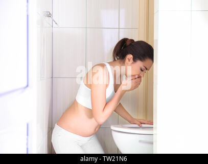 Junge erbrechen Frau in der Nähe der WC-Schüssel zu Hause Stockfoto