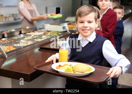 Cute girl Holding Fach mit leckerem Essen in der Schule eine Cafeteria Stockfoto