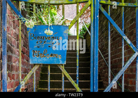 Schild am alten Tor in englischer und französischer Sprache Willkommen Stockfoto